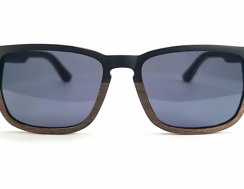 Gros plan sur les lunettes Draken mettant en valeur le contraste entre le noyer et l’ébène.