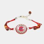Bracelet cabochon en bois avec perles d'acajou et cabochon en verre mandala rosé, posé sur une surface blanche.