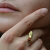 Bague ginkgo doré Amarante Luna portée sur une main féminine