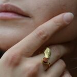 Bague ginkgo doré Amarante Luna portée sur une main féminine