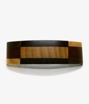 Barrette en bois de marqueterie multicouleur Lise posée sur une surface en bois, 100% fabriquée à la main avec des matières naturelles. Dimensions : 10 cm x 3 cm.