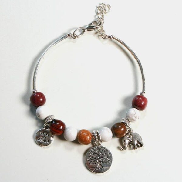 Bracelet jonc en bois Howlite Samia exposé sur un fond blanc, mettant en évidence ses perles naturelles et ses breloques argentées.