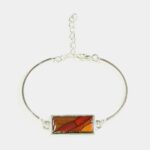 Bracelet élégant combinant une chaîne argentée avec des morceaux de bois précieux.