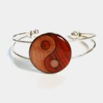 Bracelet réglable pour femme présentant un élégant design Ying Yang, fabriqué artisanalement en bois précieux.