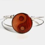 Gros plan sur le bracelet Ying Yang Solène en bois noble, orné d'un médaillon de 25mm en marqueterie unique.
