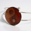 Bracelet en bois Ying Yang Solène avec médaillon en marqueterie de 25mm, conçu à partir de différentes essences de bois recouvertes de résine naturelle.