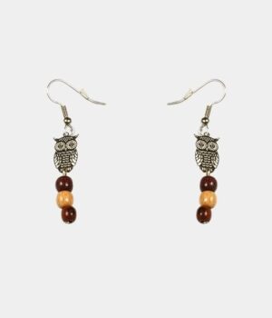 Une paire de boucles d’oreilles pendantes avec une chouette filigrane en argent et des perles de bois précieux.
