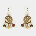 Vue détaillée du fermoir à crochet ouvert des boucles d'oreilles en bois et doré.