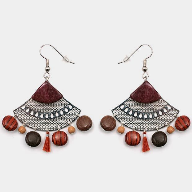 Boucles d'oreilles en bois multicolore avec détails filigranés argentés et pompons.