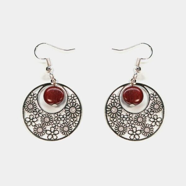 Gros plan sur une paire de boucles d'oreilles multicolores Noélie avec un design créole et des perles en bois précieux.