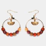 Gros plan montrant la texture et les finitions soignées des boucles d’oreilles créoles Gingko dorées Lulu.