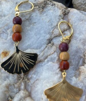 Boucles d'oreilles en bois avec trois perles multicolores et une feuille de ginkgo dorée.