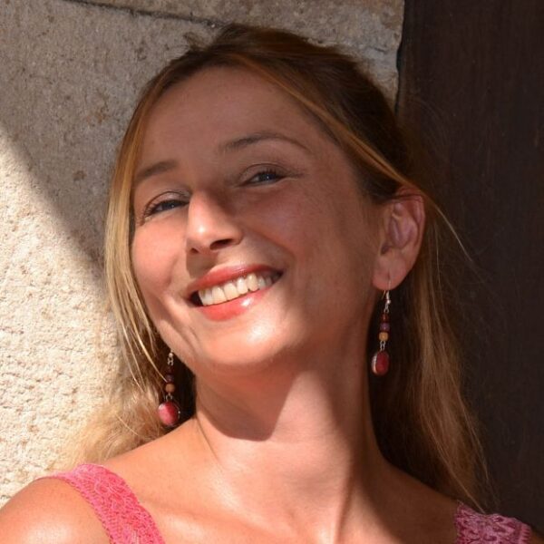 Femme portant des boucles d'oreilles en quartz cerise et bois, mettant en valeur la beauté naturelle des bijoux.