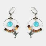 Boucles d’oreilles Oksana composées de perles en bois multicolore et d’un cabochon en turquoise naturelle.