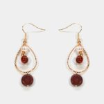 Boucles d’oreilles Sélénite et Bois Dora : Une paire de boucles d’oreilles en bois et sélénite blanche montée sur une base créole dorée.