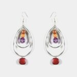 Élégance naturelle : Gros plan sur une boucle d’oreille avec une pierre d’améthyste violette et breloque feuille.