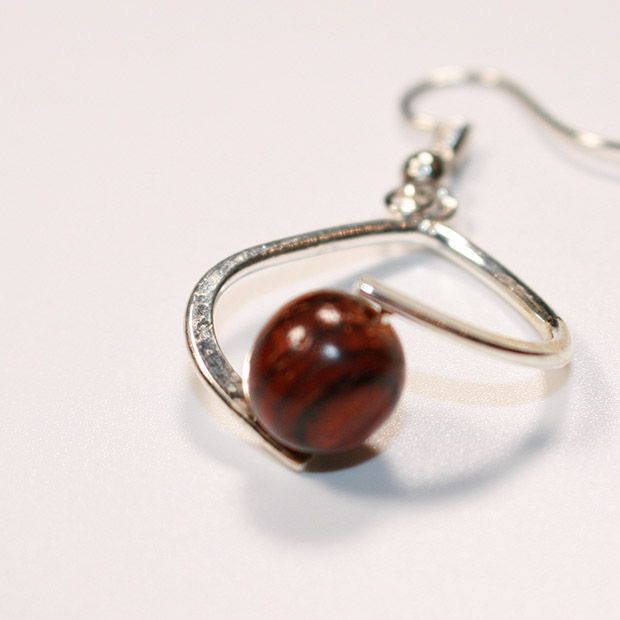 Boucles d'oreilles Falone en bois d'acajou artisanal avec un design élégant, présentées dans un fond neutre.