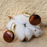 Image des boucles d'oreilles Ness en bois naturel avec une finition dorée, idéales pour les femmes recherchant des accessoires élégants et éco-responsables.