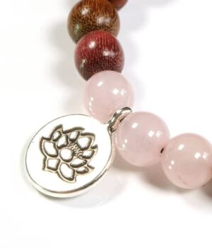 Bracelet Lotus en bois multicolore et Quartz rose porté au poignet d'une femme, montrant son élégance et son style naturel.