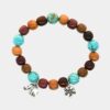 Bracelet artisanal en bois multicolore avec perles de turquoise et breloques.