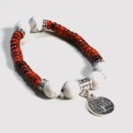 Gros plan sur la pierre Howlite blanche et le bois multicolore du bracelet Isaura, confectionné à la main pour un style authentique.