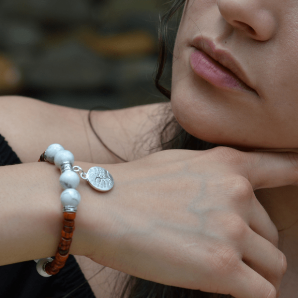 Plan rapproché du bracelet howlite Isaura mixte, mettant en valeur les pierres naturelles et l'arbre de vie.