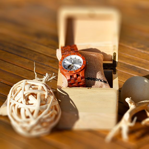 Une montre en bois de palissandre avec mécanisme squelette visible et cadran élégant.