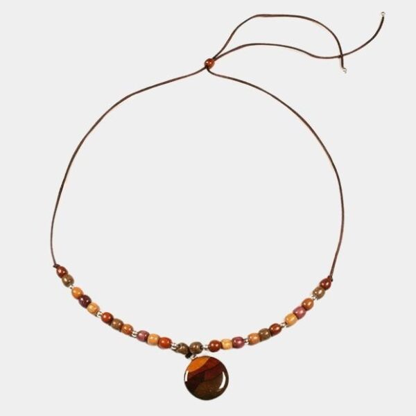 Pendentif artisanal en bois avec incrustations en marqueterie, fabriqué à la main avec des essences rares telles que l’amarante et le palissandre.