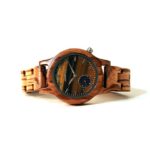 Une montre élégante pour femme avec un boîtier en bois d'ébène et un bracelet argenté, associant simplicité et raffinement.