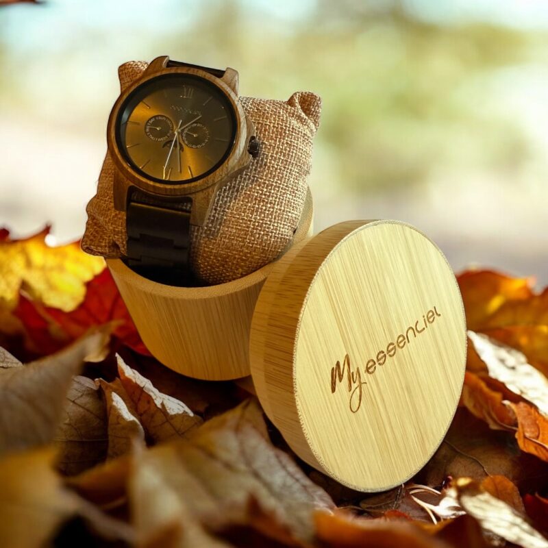 Coffret en noyer et ébène Kim My Essenciel contenant une montre en bois homme posée sur son coussin en toile naturelle, avec maillons supplémentaires.