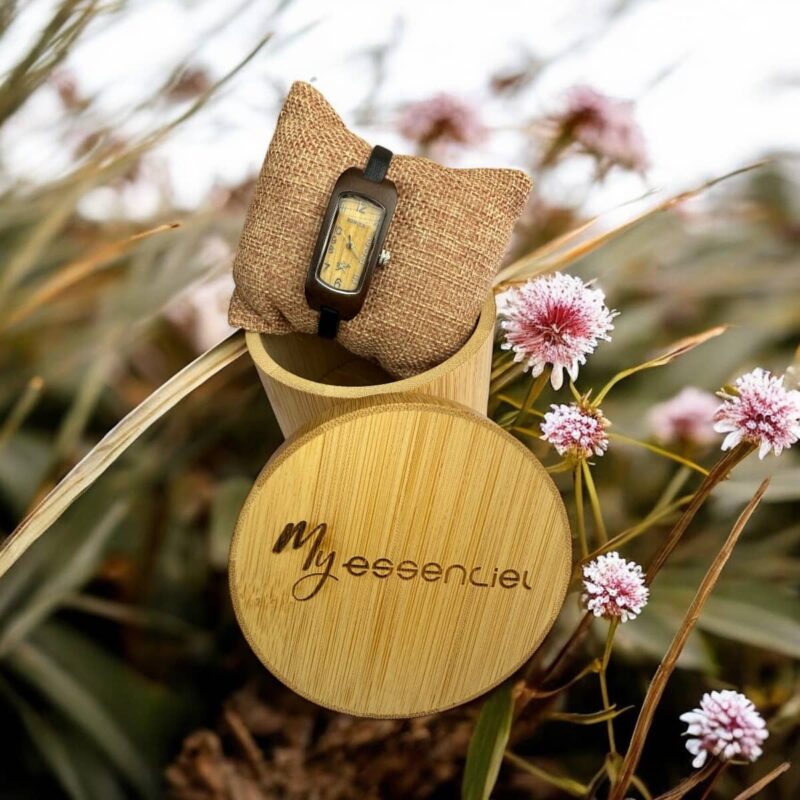 Coffret en ébène collection Carlita My Essenciel contenant une montre en bois femme posée sur son coussin en toile naturelle, avec maillons supplémentaires.