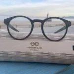 Monture en bois d’ébène Paul Optic 2 pour femmes, design intemporel et branches en acétate bio sur un fond marbre.