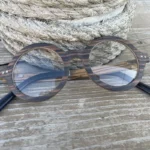 Modèle pour femme Océania en bois clair, présenté avec un étui en liège et un chiffon en microfibre.