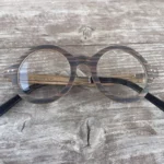 Lunettes en bois Océania posées sur une table, montrant leur design écoresponsable et forme ronde classique.