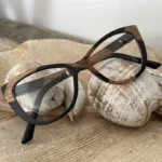 Lunettes en bois La Bicolore XP154XP pour femme sur fond blanc, mettant en avant la monture papillon en ébène et érable.
