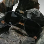 Lunettes solaires Mac-Arthur en bois d’ébène devant un fond minimaliste blanc