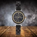 Montre en bois d’ébène Maya pour femme avec cadran doré et bracelet en bois, vue sur fond noir.