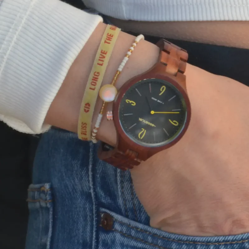 Cadran noir de la montre Aretha avec accents jaunes sur les chiffres 3, 6, 9 et 12.