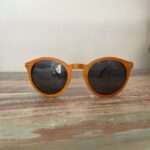Lunettes de soleil Spector Orange en bois recyclé, design multicolore posé sur une élégante surface marbrée, mettant en valeur leur originalité et leur finition artisanale.
