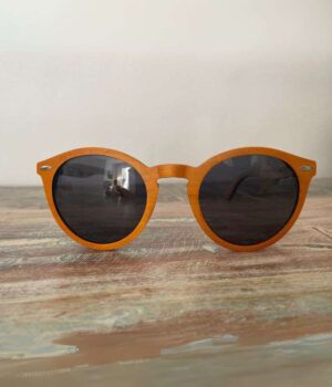 Lunettes de soleil Spector Orange en bois recyclé, design multicolore posé sur une élégante surface marbrée, mettant en valeur leur originalité et leur finition artisanale.