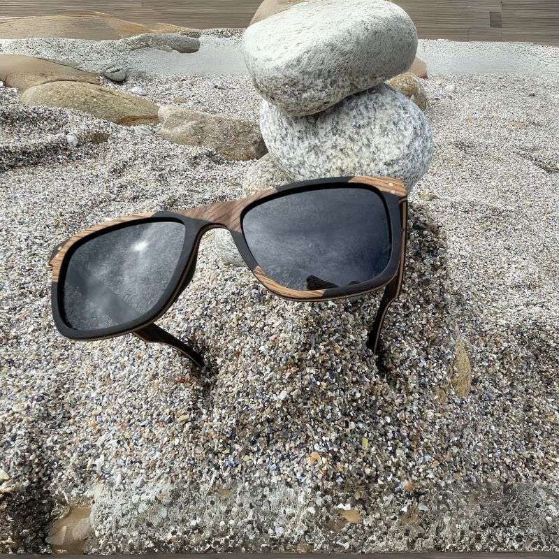 Lunette de soleil mixte avec une monture légère et écologique en bois de noyer et érable, parfaite pour les formes de visage rond, ovale ou carré. Protection UV400 incluse.