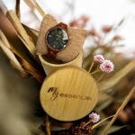 Coffret en bambou collection Arétha brown My Essenciel contenant une montre en bois femme posée sur son coussin en toile naturelle, avec maillons supplémentaires.