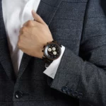 Gros plan sur le boîtier en bois de noyer massif de la montre pour homme Nomadis.