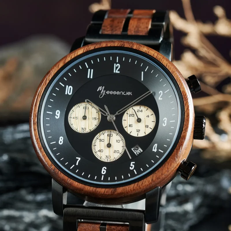 Gros plan sur le cadran de la montre chronographe en bois noir Nomadis avec trois sous-cadrans beige métallisé.