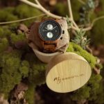 Coffret en noyer Pulsor My Essenciel contenant une montre en bois homme posée sur son coussin en toile naturelle, avec maillons supplémentaires.