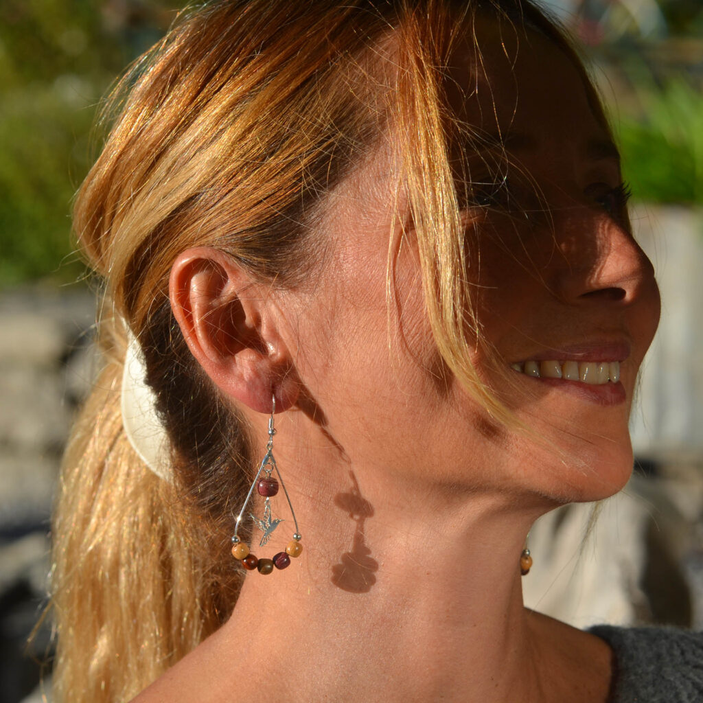 Photo lifestyle des boucles d'oreilles bois colibri Serrenna portées, illustrant un look décontracté et chic, parfaitement adapté pour compléter une tenue sophistiquée.