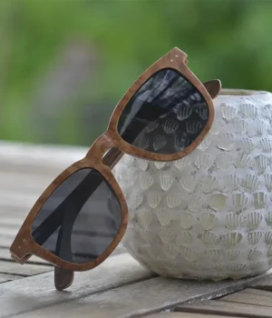 Lunettes en bois DOUGLAS MARRON CLAIR posées sur une table en bois avec une lumière naturelle.