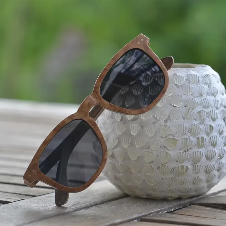 Lunettes en bois DOUGLAS MARRON CLAIR posées sur une table en bois avec une lumière naturelle.