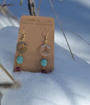 Zoom sur la pierre turquoise éclatante des boucles d’oreilles Anna, montée sur une structure dorée raffinée.